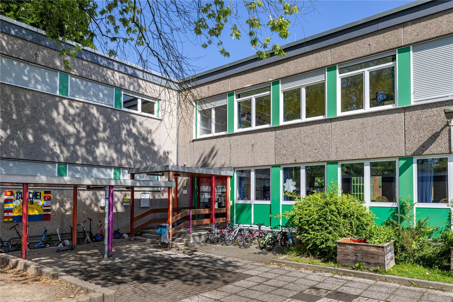 Die Buscheigrundschule ist ein zweigeschossiges Gebäude mit grünen Fronten.