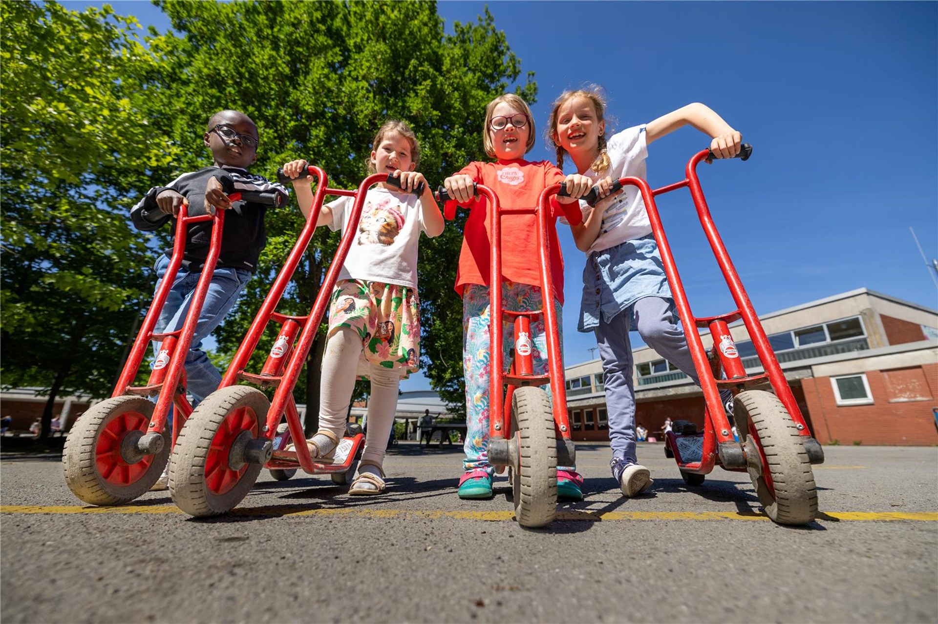 Kinder stehen mit den Rollern